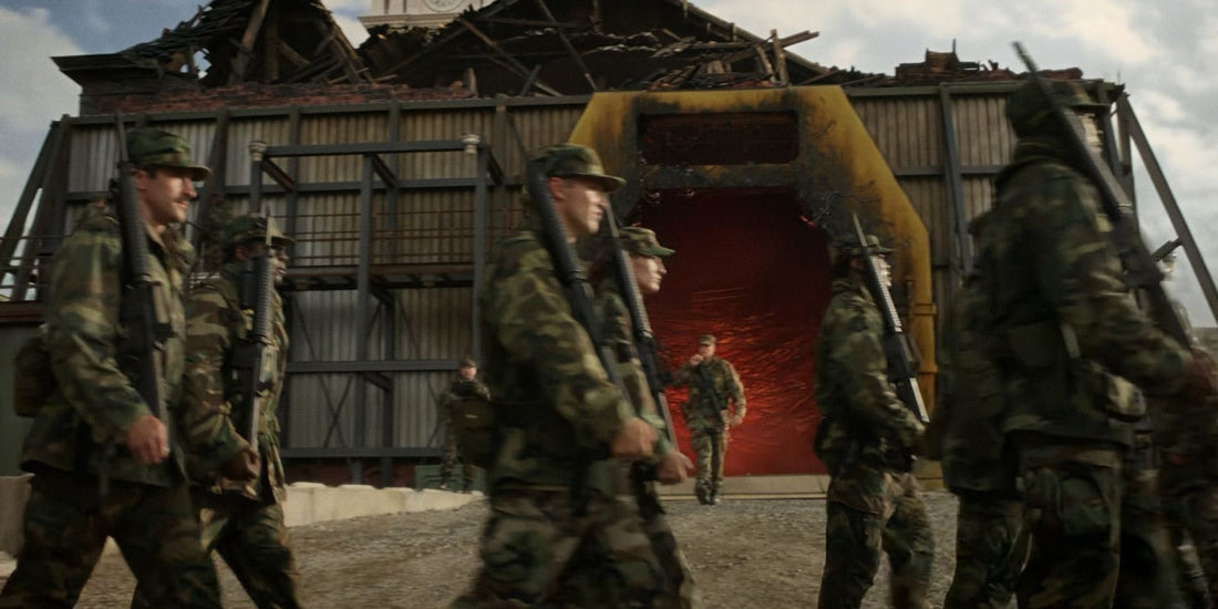Soldats en treillis devant une ouverture rouge, dans un bâtiment à la toiture arrachée.