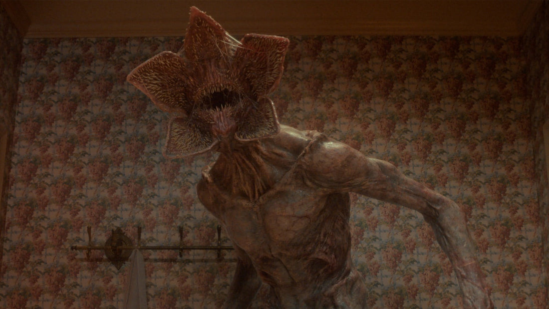 Le Demogorgon, gueule ouverte, dans une chambre au papier peint fleuri