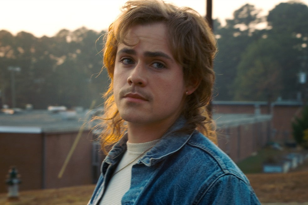 Billy Hargrove, le frère de Max, en veste de jean, le regard tourné de côté