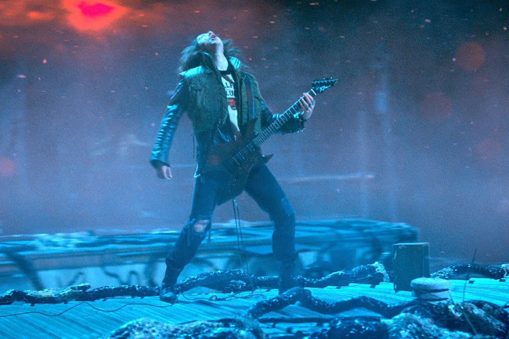 Eddie Munson joue la guitare Stranger Things, tête renversée, sur le toit de l'Envers