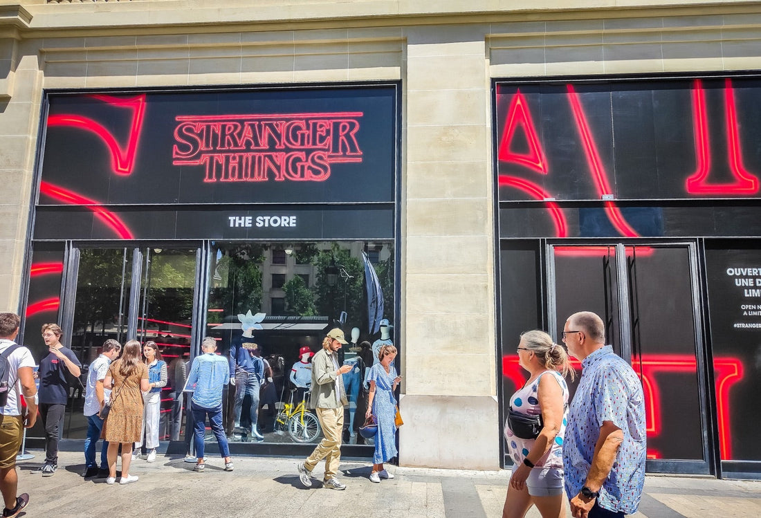 Devanture éclairée d'une avenue parisienne, vitrine sombre et lettres rouges