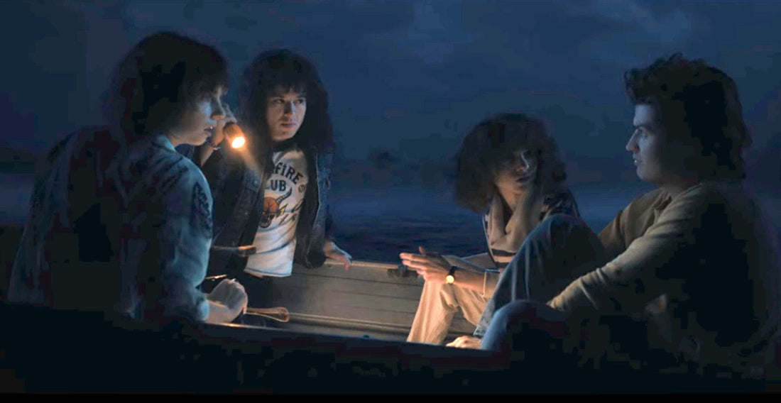 Quatre adolescents dans une barque, de nuit, une lampe à la main, Stranger Things saison 4 épisode 6