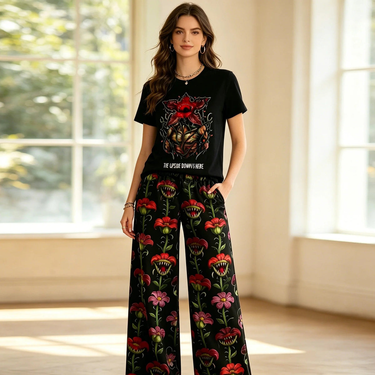 Femme portant le pyjama Stranger Things t-shirt noir Demogorgon et pantalon large fleuri