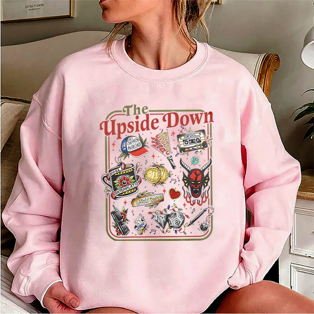 Sweat col rond Stranger Things The Upside Down objets cultes rose, objets de la série en tatouage rétro sur le devant